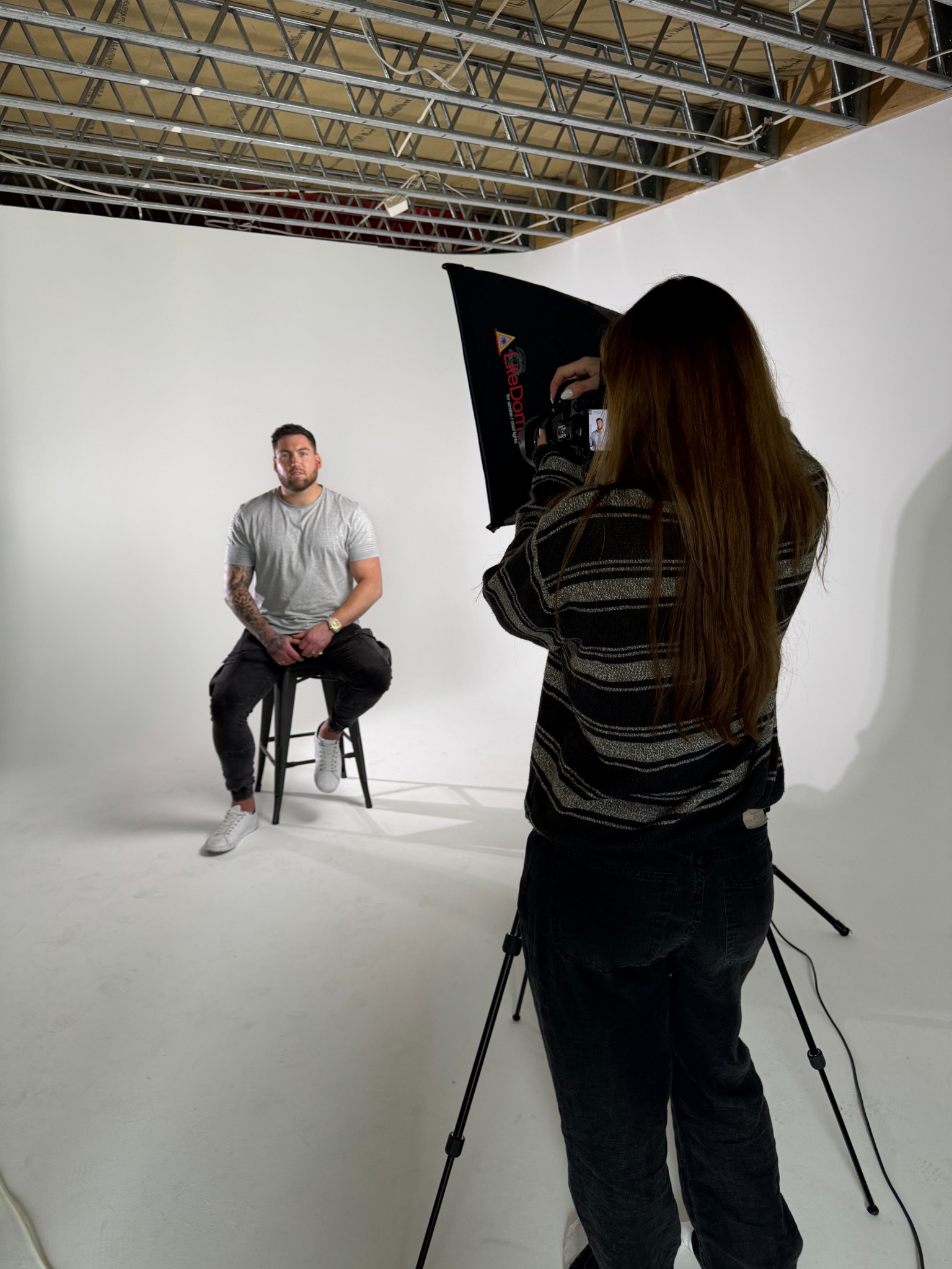BTS of talent being filmed on the cyclorama stool